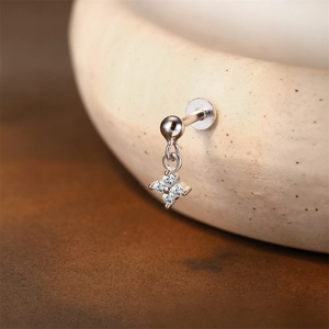Detailed shot of a silver S925 floral cartilage stud with four clear zircon stones