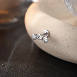 Foto macro de pendiente de plata de ley S925 con tres piedras brillantes de moissanita