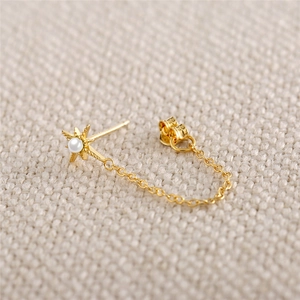 Dettaglio orecchino a stella in argento S925 dorato con perla d'acqua dolce e catena