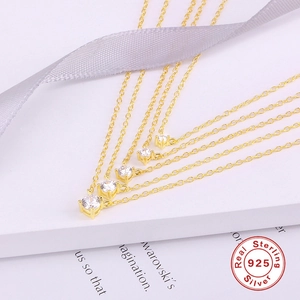 Collares minimalistas de plata S925 dorada con circonitas sobre fondo de seda