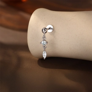 Macro shot of silver cartilage piercing with round and marquise moissanite stones