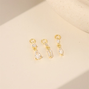 Detail of three gold plated S925 silver geometric charms with sparkling zircon stones
