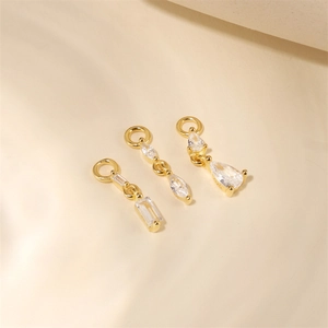Macro view of S925 sterling silver gold-plated charms with marquise and emerald cut zircons