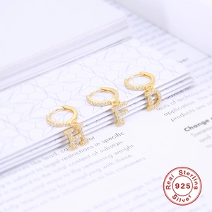 Dettaglio di orecchini a cerchio in argento sterling 925 con lettere e cristalli