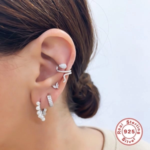 Détail de boucles d'oreilles superposées en argent 925 avec serpent zircon et perles