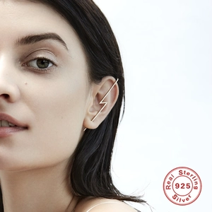 Close-up of golden S925 sterling silver lightning bolt ear cuff with paved zircon stones