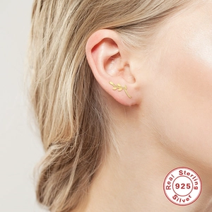 Detailed view of a gold branch-shaped S925 sterling silver earring on a model's ear