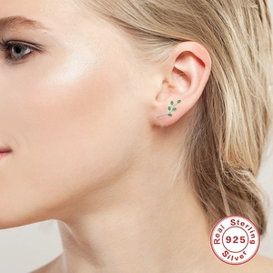S925 sterling silver branch stud earrings with green leaves on model's ear
