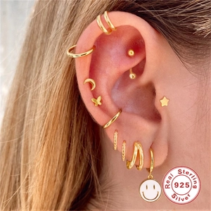 Detail of 925 sterling silver gold earrings set with star and moon charms on model