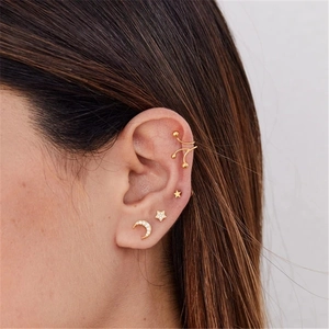 Vue détaillée d'un ensemble de boucles d'oreilles étoile et lune en argent 925 doré