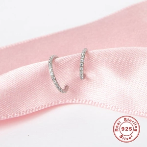 Vue macro de créoles en argent sterling avec pavé de zircons sur ruban de satin rose
