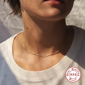 Detail einer 925 Sterling Silber Goldhalskette mit minimalistischen Stabanhängern am Modell