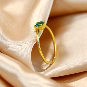 Luxury S925 sterling silver emerald ring with 18k gold plating on elegant silk backdrop
