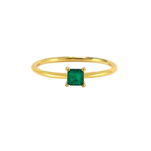 Macro shot of emerald-cut green gemstone with four-prong setting on gold ring