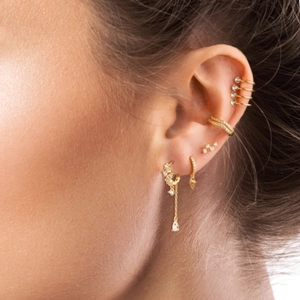 Detailansicht vergoldeter Earcuffs und Ohrringe mit Zirkonia-Anhängern und Sternen