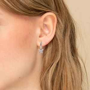 Close-up of S925 silver butterfly earrings with sparkling cubic zirconia on a model's ear