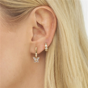 Detail of gold butterfly zircon earrings and stud set worn on a model ear