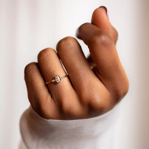 Macro view of oval halo engagement ring with pavé diamond setting and gold finish
