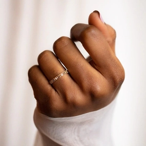 Close-up of a gold-plated beaded ring with diamonds worn on a finger for an elegant look