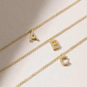 Macro view of gold S925 silver A, B, C initial letter charms with micro-pave zircons