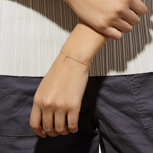 Close-up of minimalist gold S925 silver bracelet featuring a sparkling zircon letter T charm