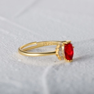 Detail of S925 silver adjustable ring with red oval gemstone and gold plating