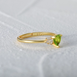 Macro view of S925 sterling silver ring with heart green gemstone and gold plating