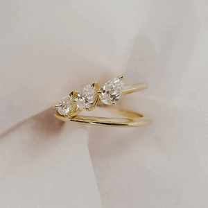 Macro detail of three pear-cut diamonds on a double-layer gold plated ring band