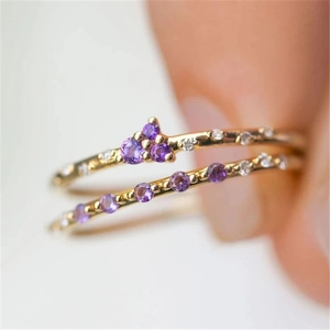Detail of double-layer gold plated silver ring set with purple zircons and clear stones