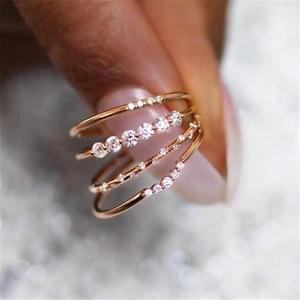 Macro detail of rose gold layered rings with cubic zirconia on a model hand