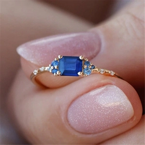 Detail of s925 silver ring with rectangular blue gemstone and gold-plated finish