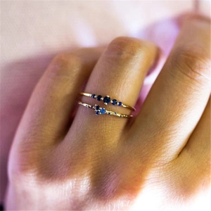 Macro shot of double-layered S925 silver ring set with vibrant blue crystals on finger