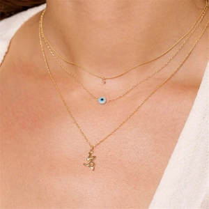 Detalle de collares de capas en plata S925 dorada con ojo de la suerte y signo Capricornio
