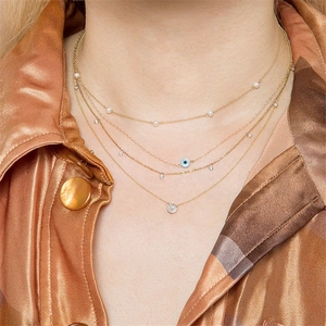 Detalle de collares de capas en plata S925 con ojo de la suerte y colgante de perla