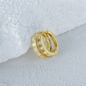 Macro shot showing S925 hallmark and square zircon inlays on gold hoop earrings