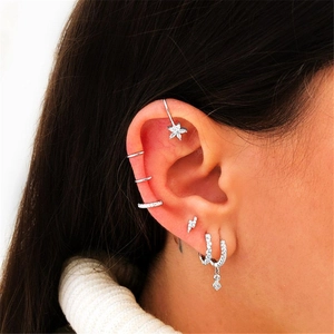 Close-up of S925 sterling silver eye and star earrings set with crystals on ear
