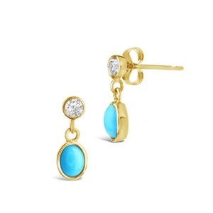 Detalle de pendientes colgantes dorados con diamante redondo y piedra turquesa ovalada