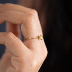 Nahaufnahme eines Goldrings mit rundem gelbem Edelstein und seitlichem Diamantbesatz