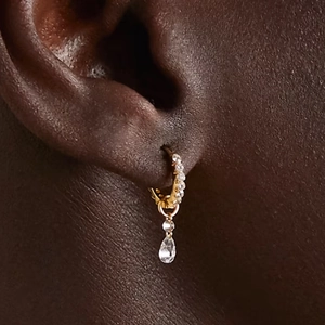 Vista macro de pendientes de aro dorados con colgantes de circón en forma de gota