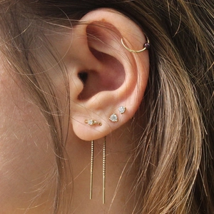 Dettaglio degli orecchini a nappa in argento 925 e set di perni in zircone indossati sul modello