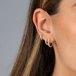 Close-up of three graduated gold S925 silver hoop earrings with pavé moissanite stones