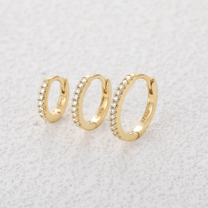 Macro shot of S925 sterling silver stamp on gold-plated huggie hoop earrings