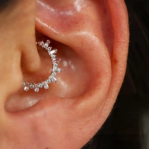 Detalle macro de pendiente de cartílago en plata S925 con circonitas brillantes engastadas