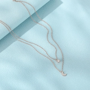 Dettaglio macro della collana doppia in argento con pendenti a luna e pietre di zircone