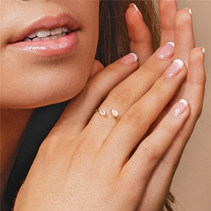 Primer plano de anillo ajustable de oro con dos piedras de luna en dedo femenino