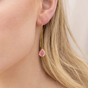 Dettaglio dell'orecchino a filo dorato con gemma a goccia rosa champagne a pera