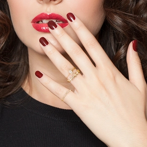 Detailed view of three-piece gold ring set with marquise stones and leaf motifs on hand