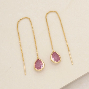 Dettaglio di orecchini a catenella in argento S925 dorato con pietre rosa a goccia