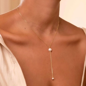 Primer plano detallado de un collar en Y de plata S925 dorada con perlas blancas