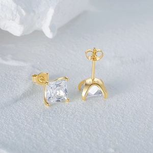 Détail d'une boucle d'oreille en argent S925 doré avec zircon carré à quatre griffes